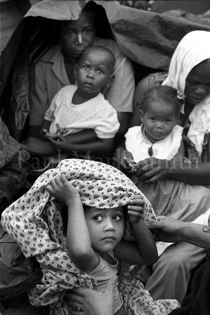 A young girl and mothers with children in a wooden boat