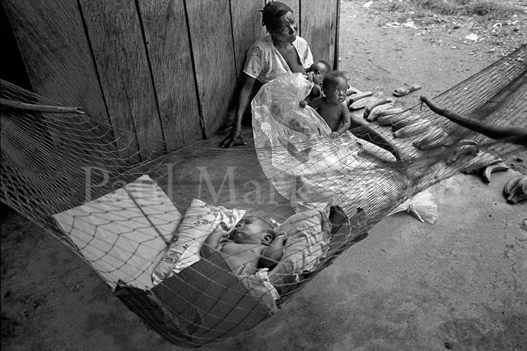 A displaced mother with three children sells plantains, a baby sleeps in a hammock