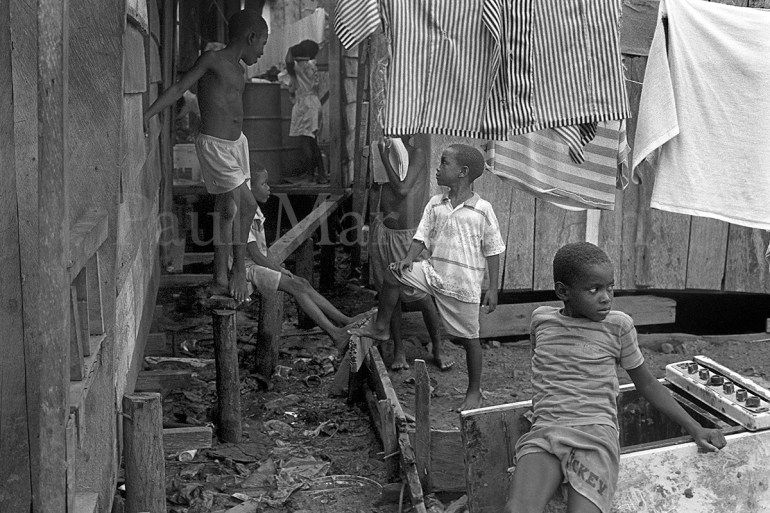 Displaced children in an area of wooden homes