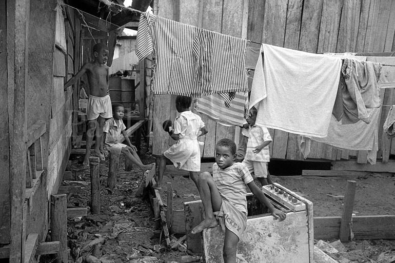 Displaced children in an area of wooden homes