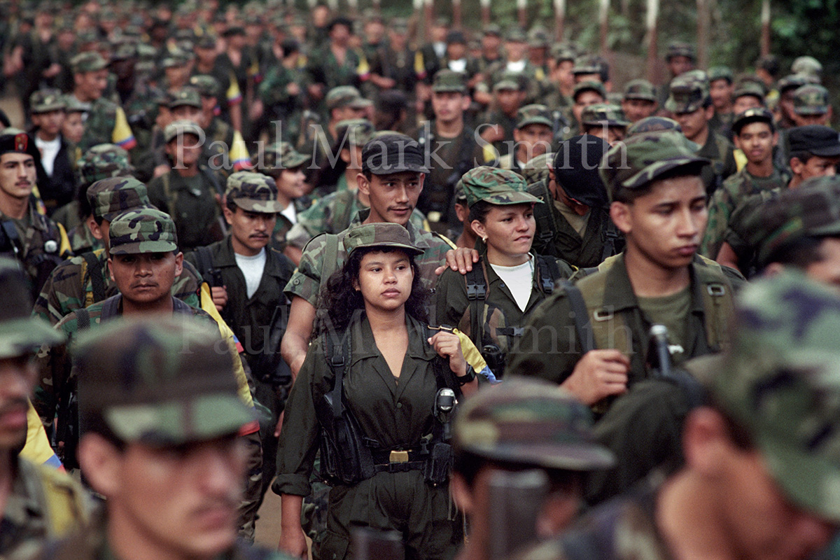 Hundreds of FARC guerrillas gathered and walking along a dirt road