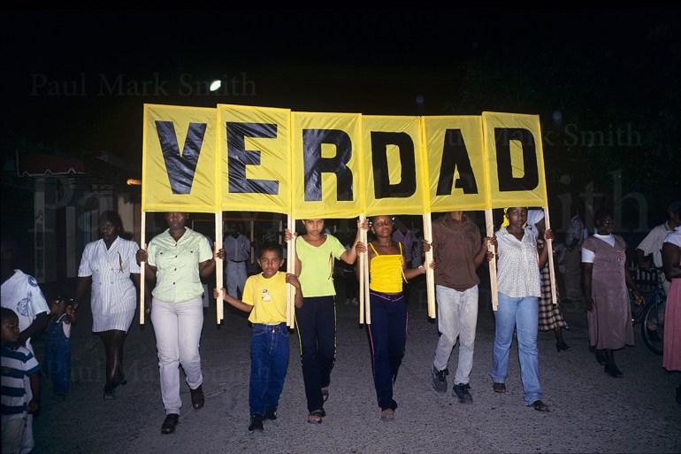 The displaced community from Salaquí carry a banner asking for "Truth" in a march to commemorate those killed and displaced in Operation Genesis
