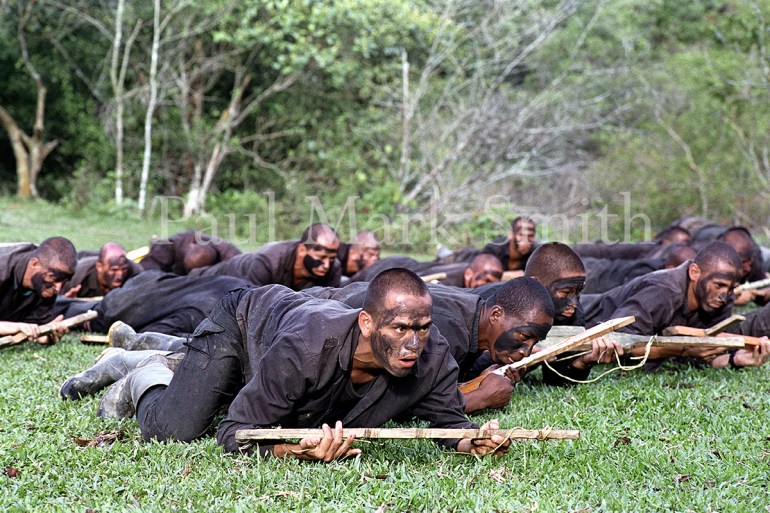 Youths train with wooden weapons in paramilitary encampment of the Metro Block