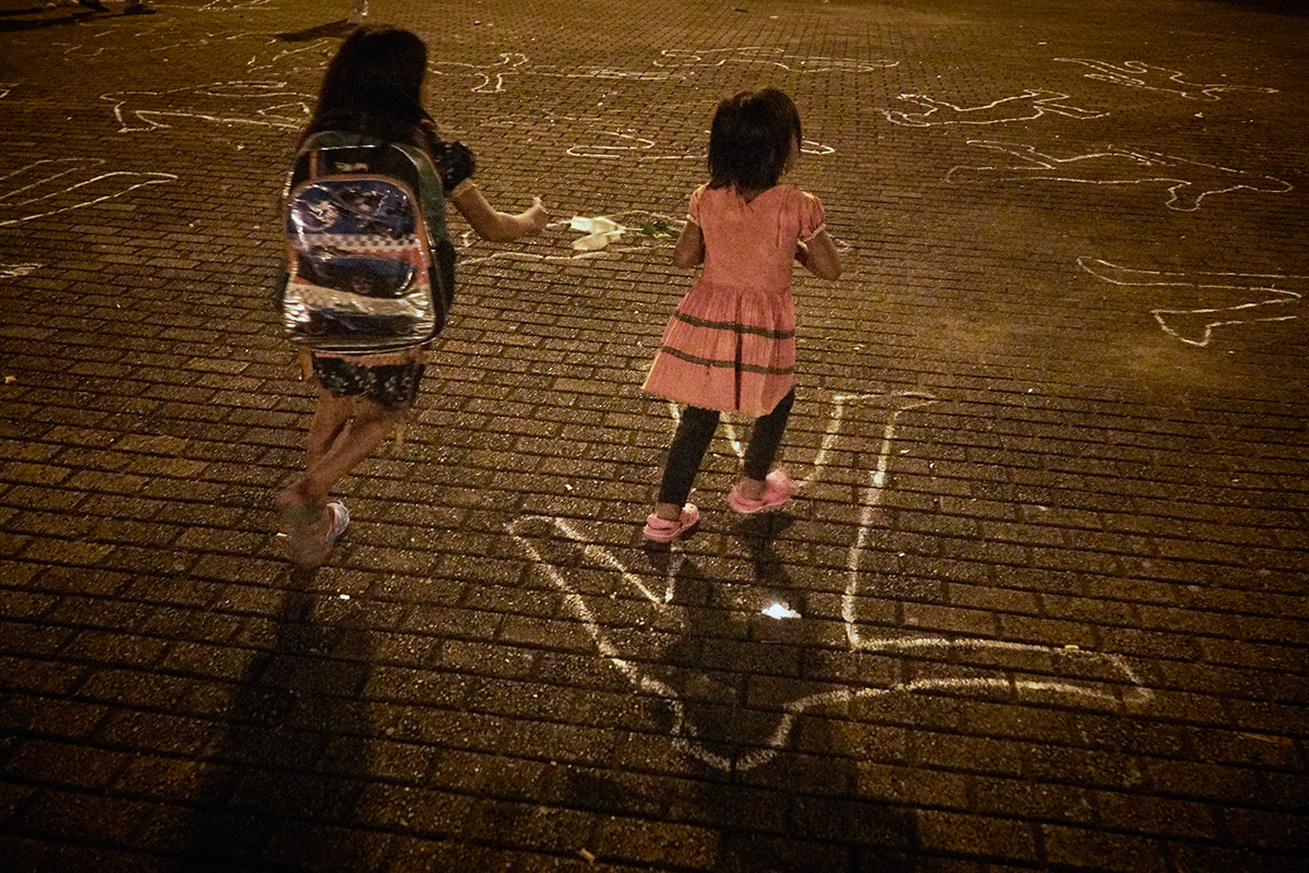 Indigenous girls run across painted forms of bodies