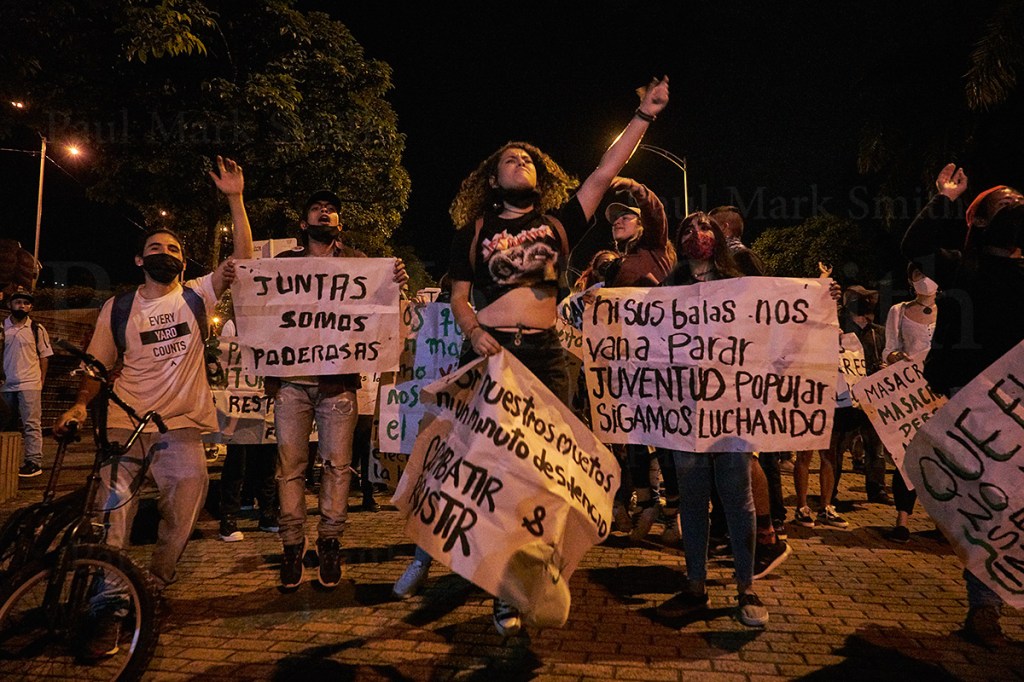 ouths leap with protest placards at night