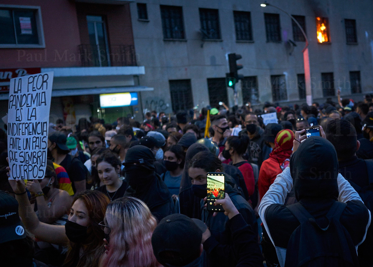 Fire emerges from window and people film on cell phones