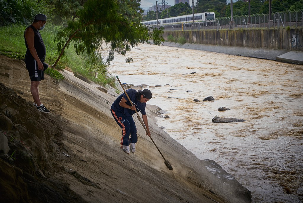 A man sweeps the banks of a river