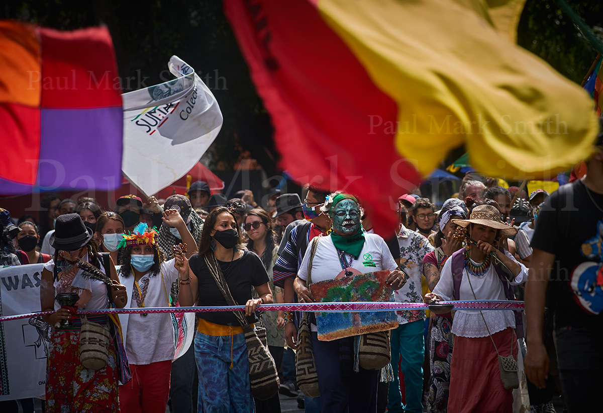 Flags flutter and people march with painted faces