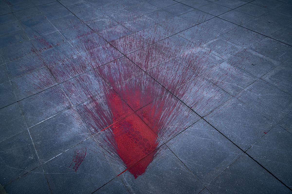 Red paint splashed on pavement