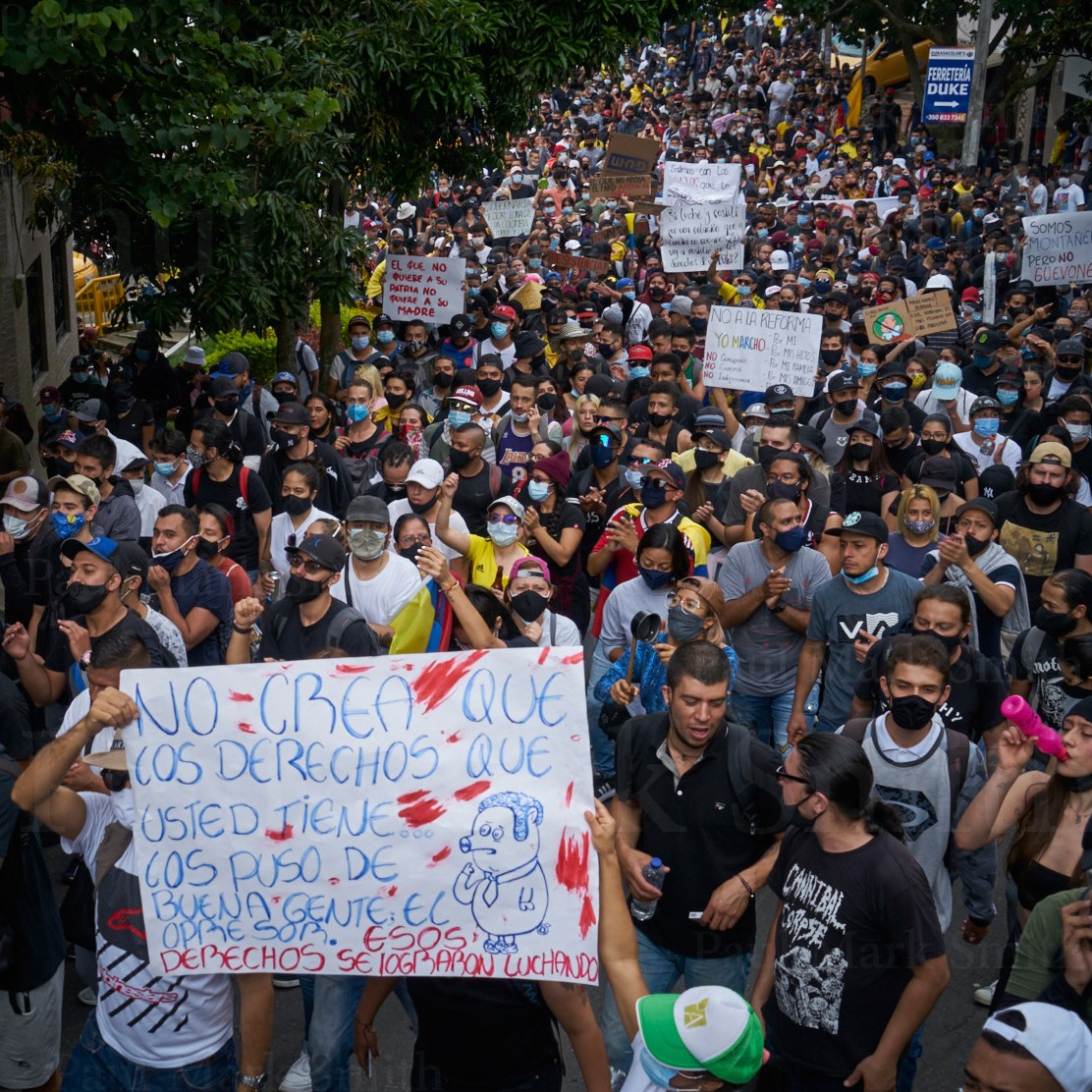 Massive crowd with banners fills a street during a protest
