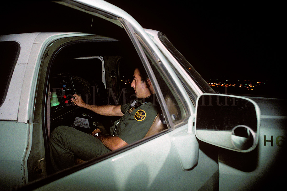 Border Patrol agent looks at screens from infra-red cameras